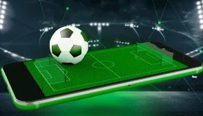 imagem de destaque onde na tela do celular há um campo de futebol e uma bola sobre o celular