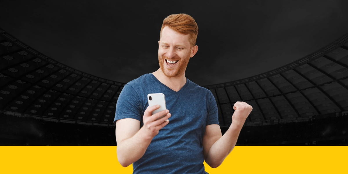 imagem mostra homem sorrindo e comemorando com smartphone na mão