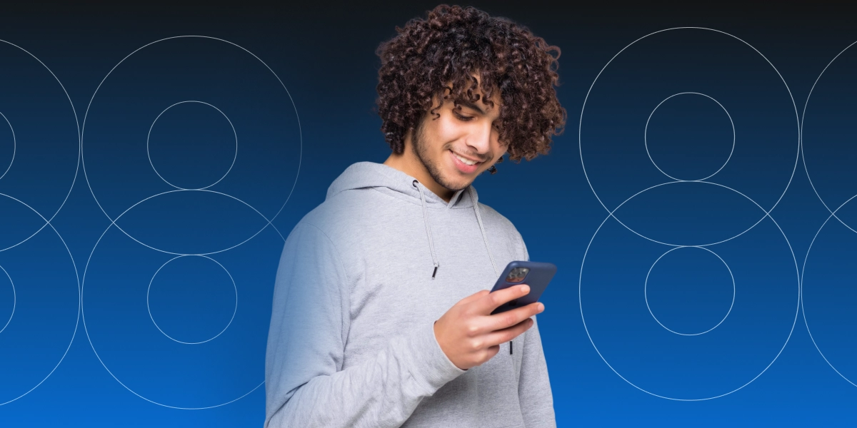 Imagem mostra homem sorrindo ao utilizar um smartphone