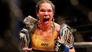 Imagem da lutadora Amanda Nunes, com seus dois cinturões conquistados sem derrotas, um feito histórico na história do UFC, que apenas outros quatro atletas alcançaram