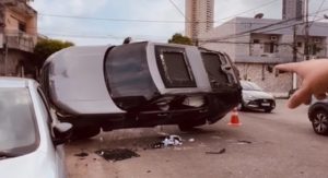 Imagem de veículo, modelo pick-up- tombado no meio da rua, após uma colisão que levou ao capotamento. 
