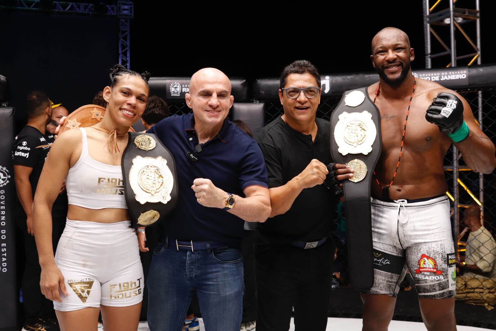 Wallid Ismail (ao centro) posa junto à um parceiro do evento com Layse Cerqueira (à esquerda) e André Monstro (à direita), exibindo seus cinturões conquistados no Jungle Fight 142 no Rio de Janeiro.