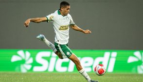 Jogador de futebol do Palmeiras Sub-20, vestindo uniforme branco e verde, prepara um chute com a perna direita durante partida da Copa São Paulo de Futebol Júnior (Copinha).