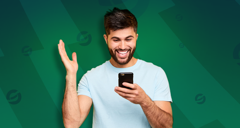Imagem mostra homem sorrindo ao utilizar um smartphone
